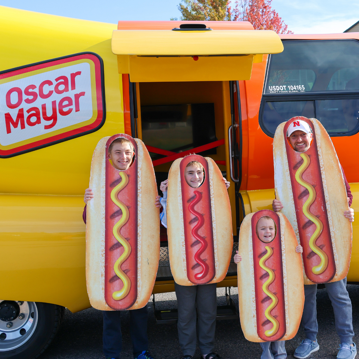 Touch a Truck Event | family wearing hotdog cutouts in front of the Oscar Mayer Wienermobile