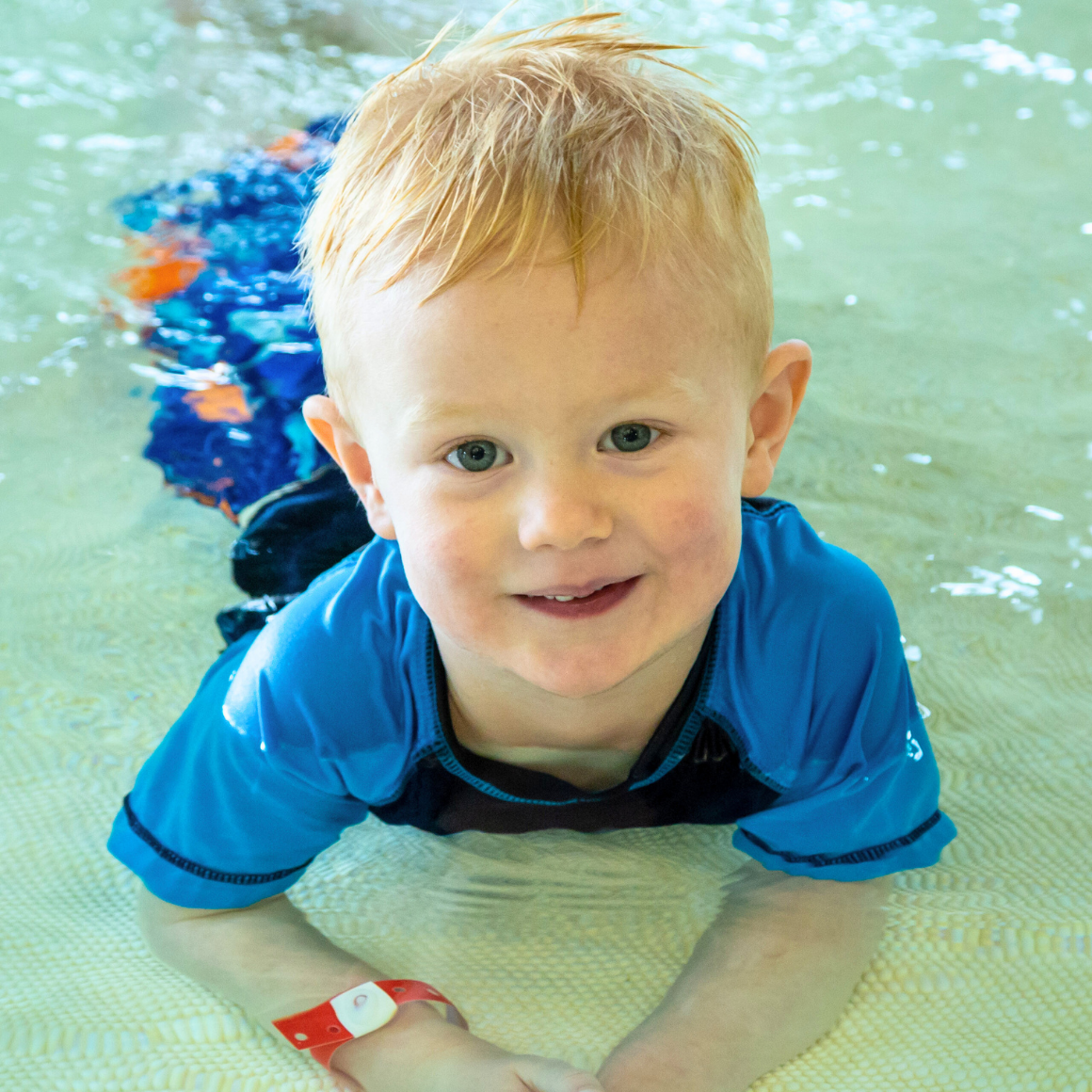 Trails Aquatics | Young child smiling while in the pool