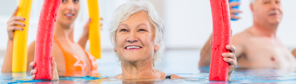 SilverSneakers or Renew Active female member doing Aqua Fitness with a pool noodle