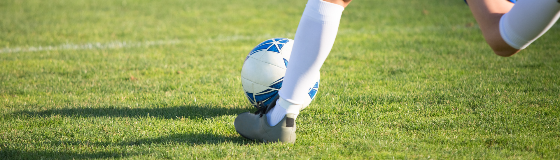 Adult Soccer League Header | image of an adult going to kick a soccer ball on a soccer field