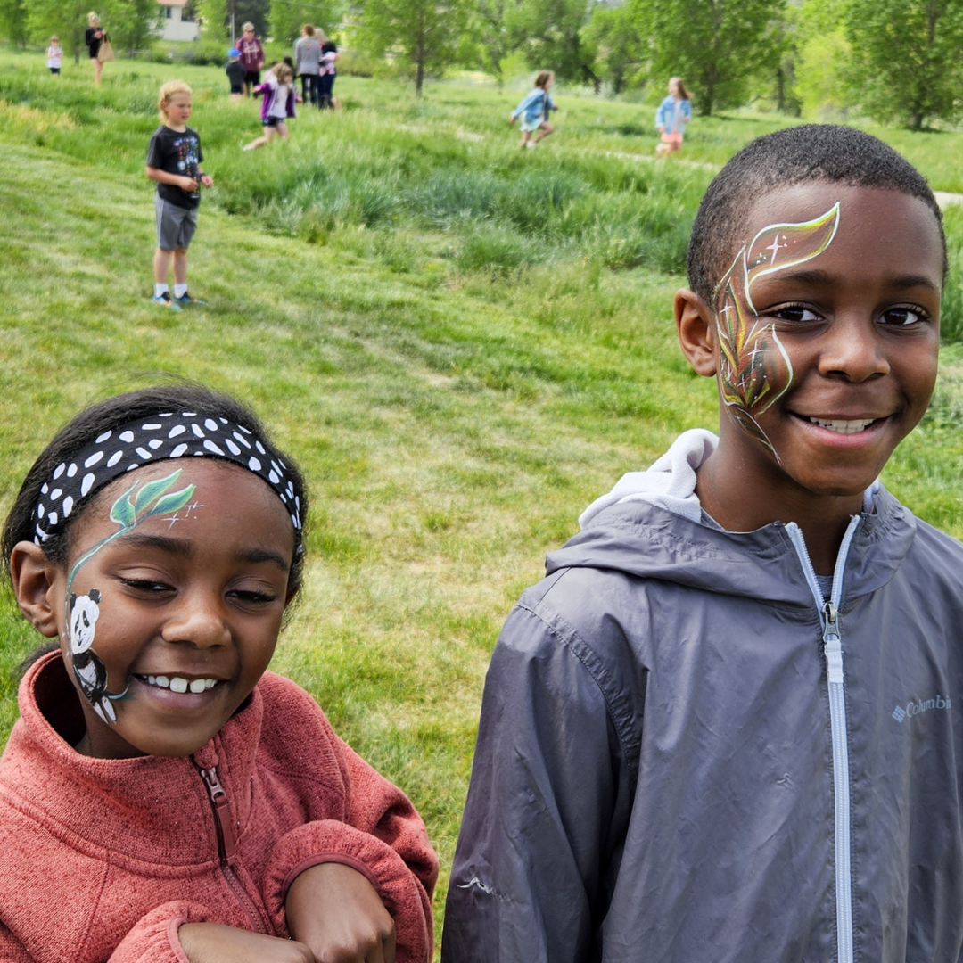 Summer Celebration 2024 | Two kids (boy and girl) smiling at the camera with a face paint design. The girl has a panda bear, the boy has a series of leafy swirls.