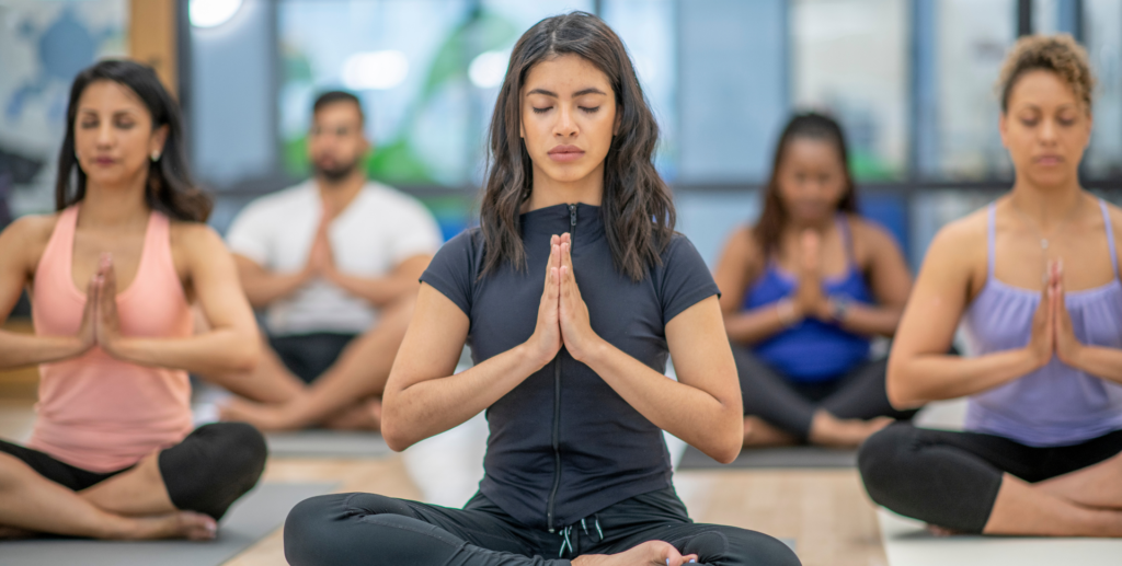 Yoga Studio Near Me | people in a yoga class in lotus position