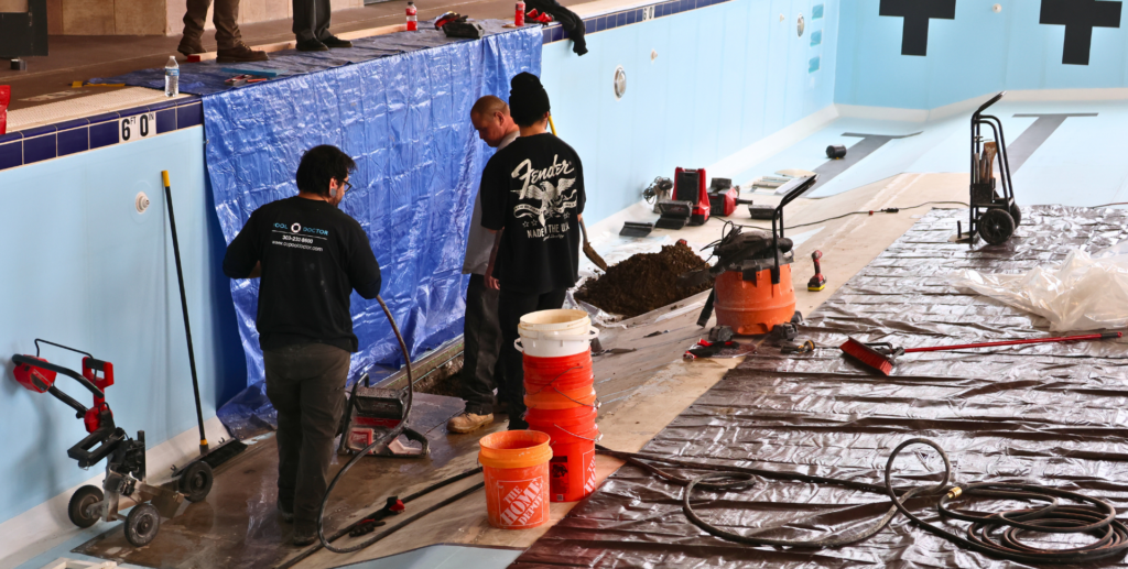 Lap Pool Closure Update 2 | Image of 3 men in an empty lap pool digging into the concrete to expose piping